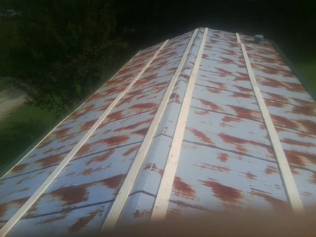 Rusted metal roof panels with new wood purlins before replacement — Storm Damage Roof Repair in Manley by Roofing Brothers